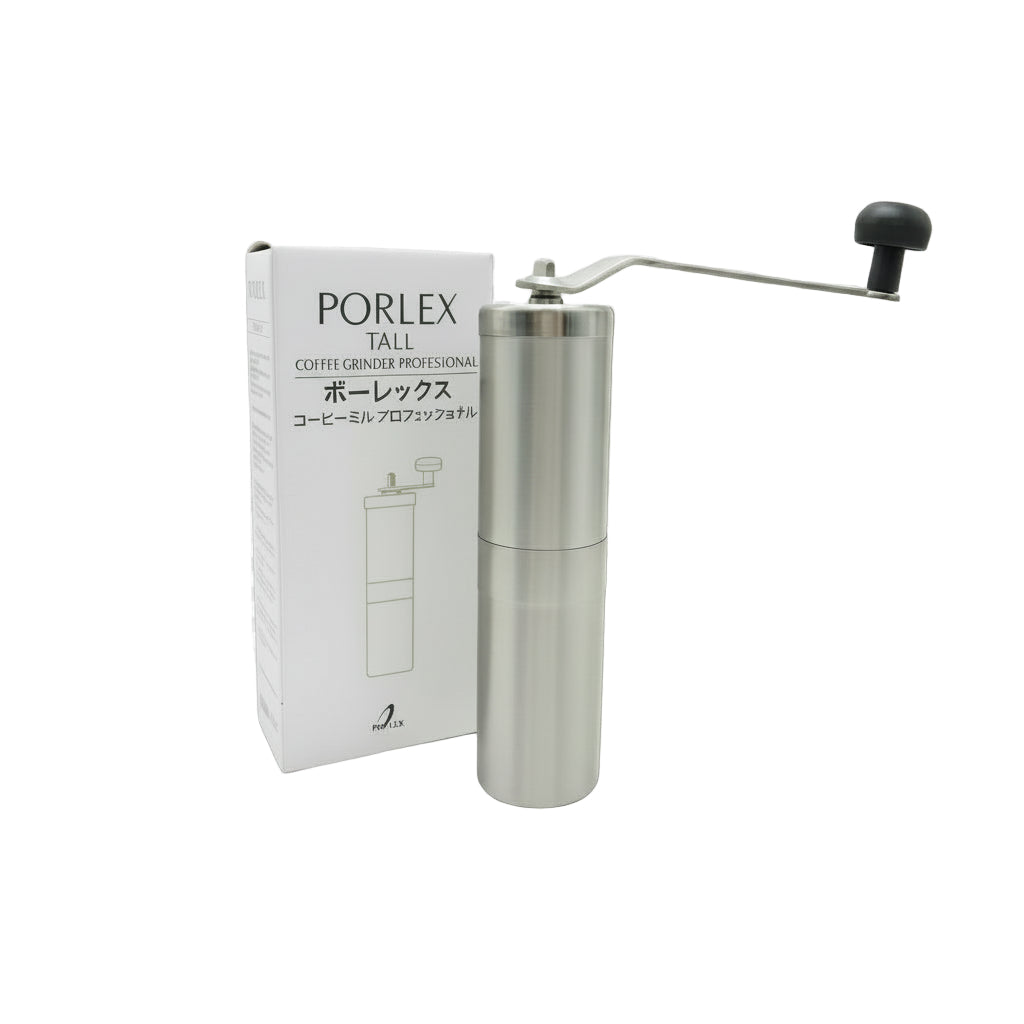 Stainless steel manual coffee grinder next to its packaging on a white background