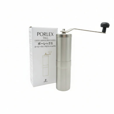 Stainless steel manual coffee grinder next to its packaging on a white background